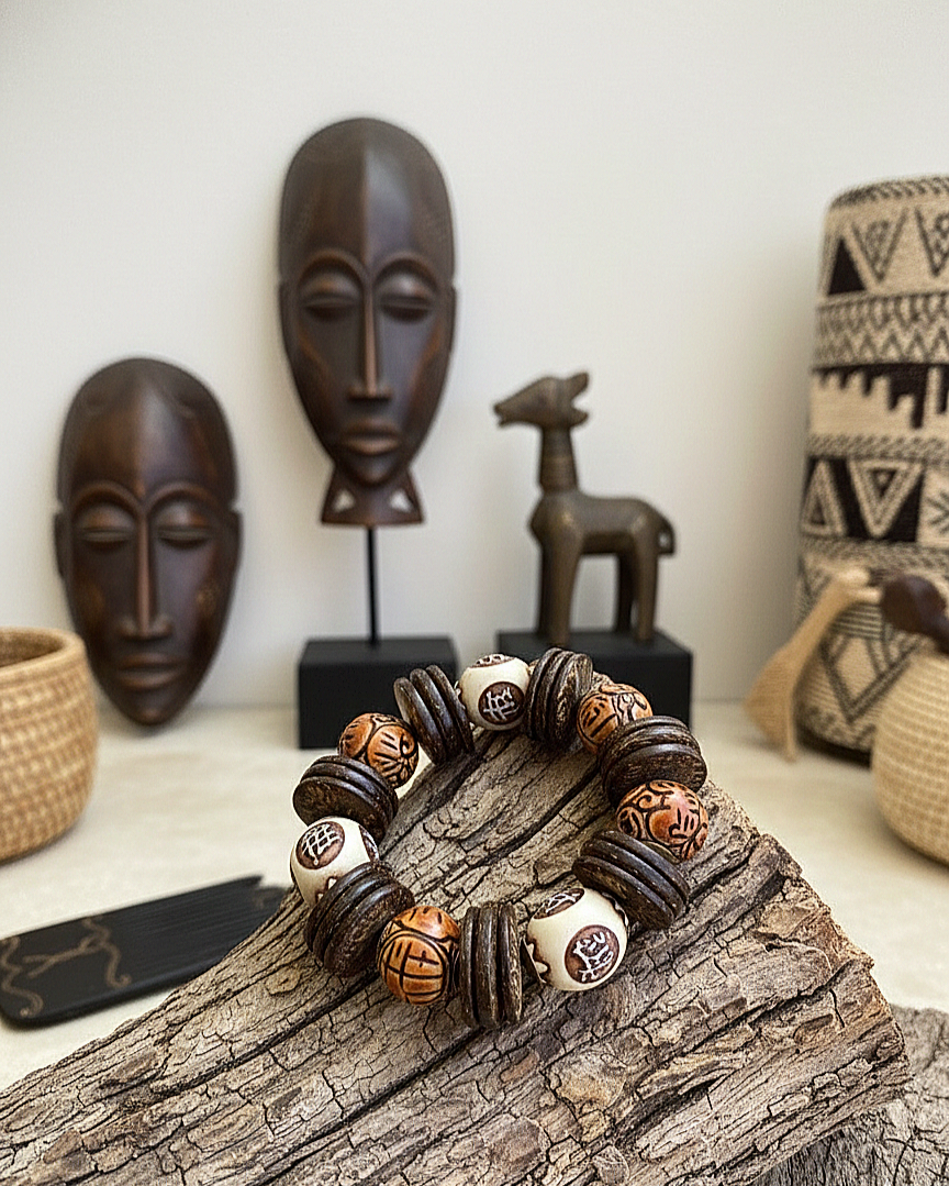Decorative bracelet with beads on a wooden log, surrounded by African-themed decor items.