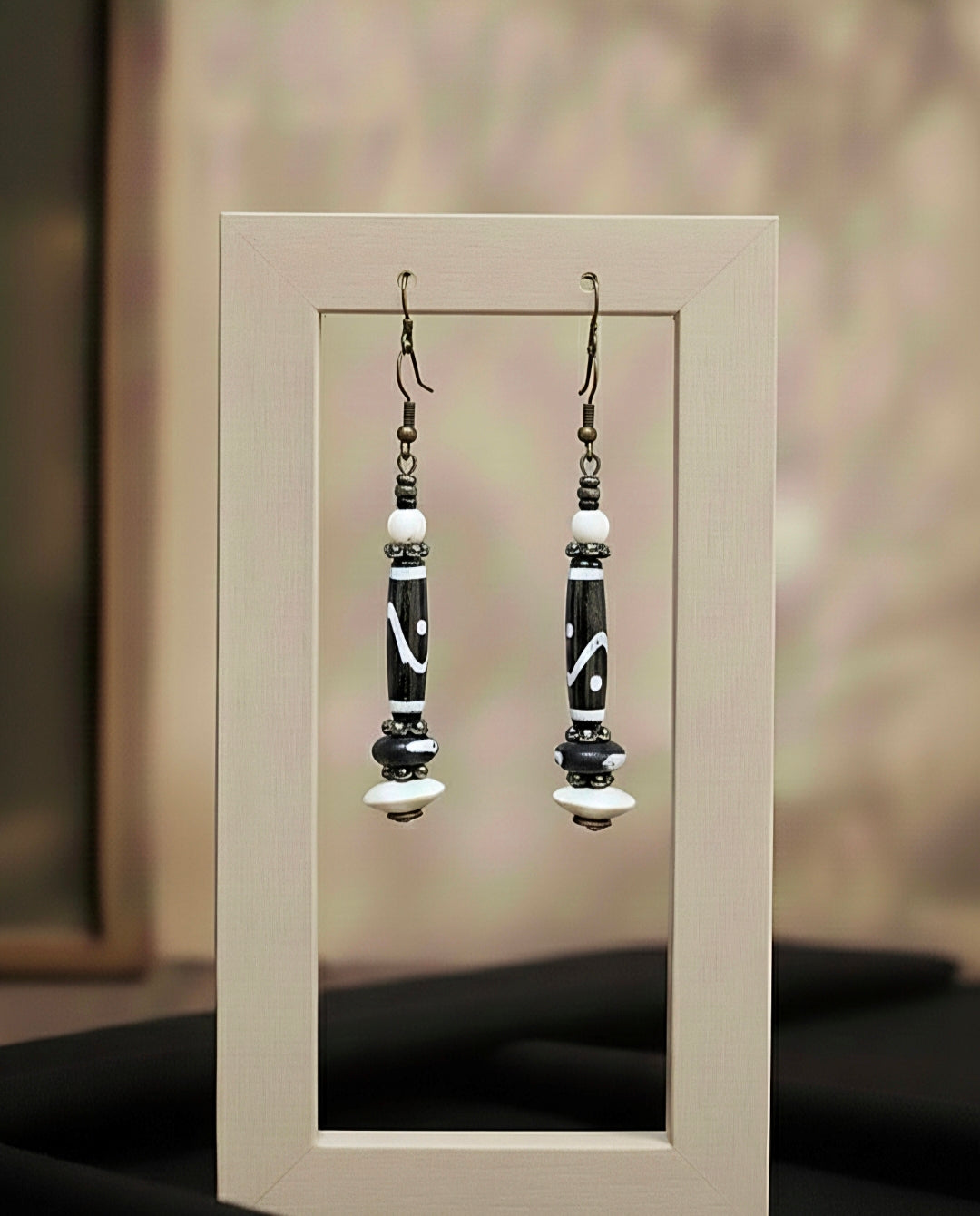 Pair of black and white beaded earrings on a neutral background