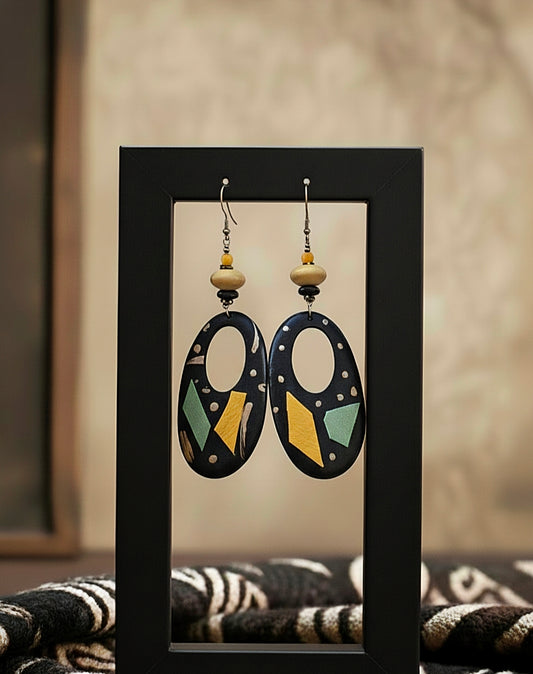 Pair of earrings displayed in a black frame against a neutral background