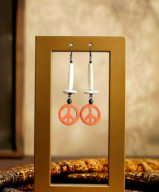 Peace sign earrings displayed in a gold frame against a neutral background