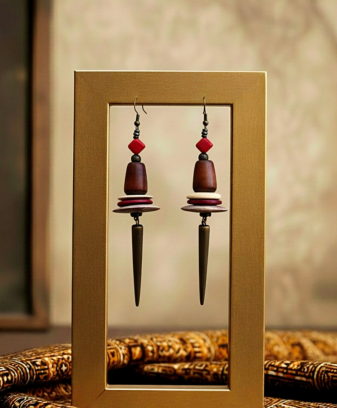 Pair of earrings with red and brown beads in a gold frame.