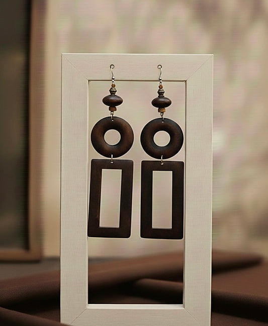 Pair of brown wood earrings on a white card with a blurred background