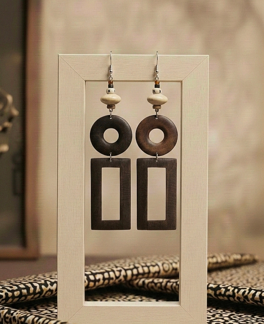 Pair of earrings displayed on a stand with a neutral background
