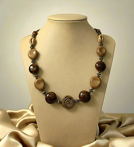 Necklace with brown beads on a beige mannequin against a beige background