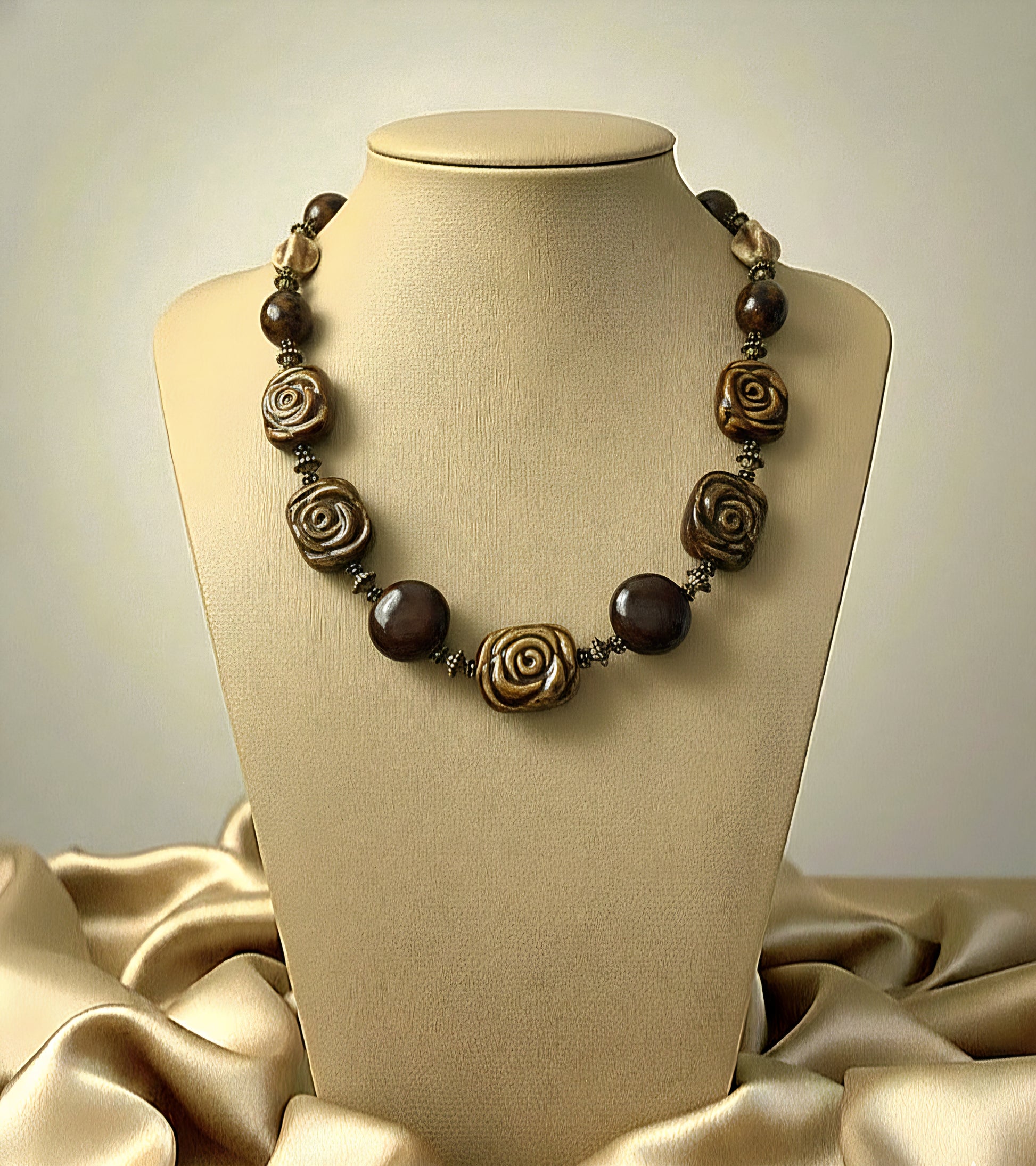 Necklace with brown and gold beads on a mannequin bust against a beige background
