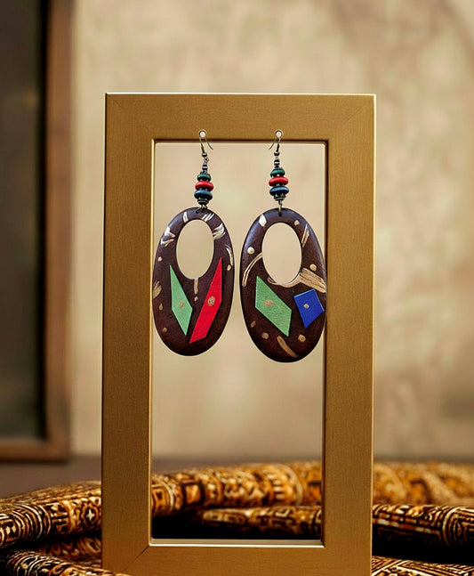Pair of colorful wood earrings displayed in a gold frame.