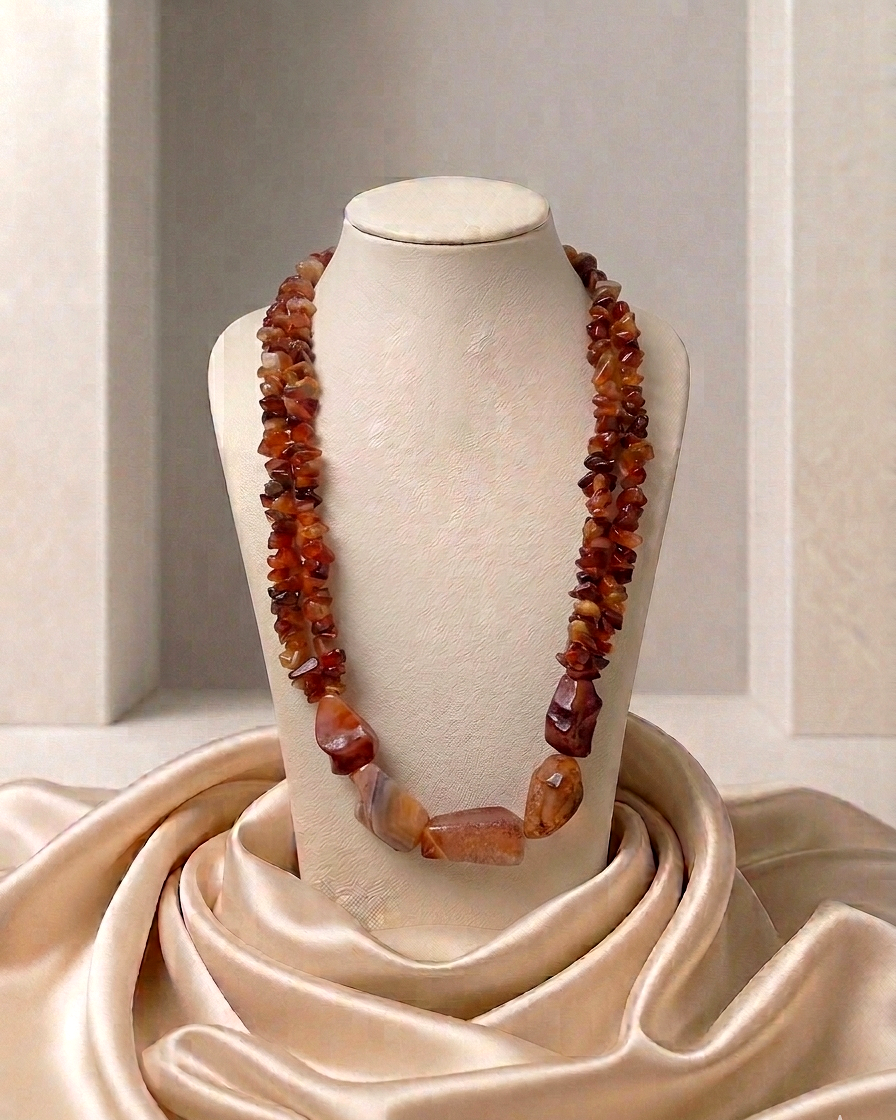 Necklace with amber-colored beads on a mannequin bust against a neutral background