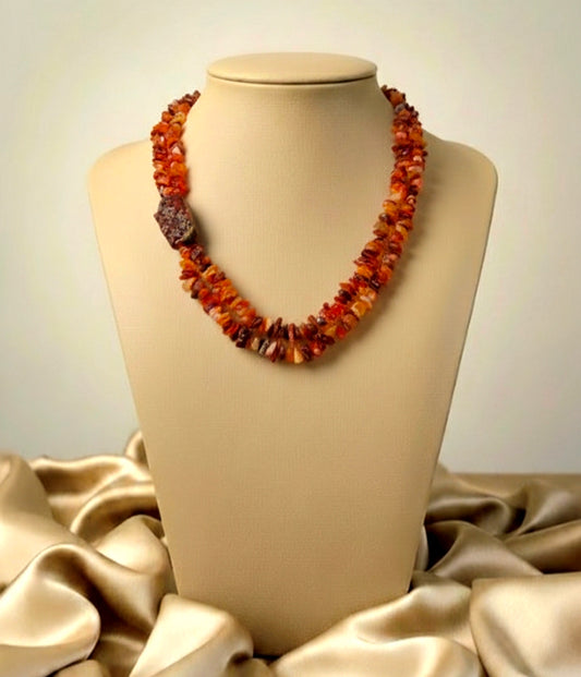 Necklace with amber-colored beads on a mannequin bust against a neutral background