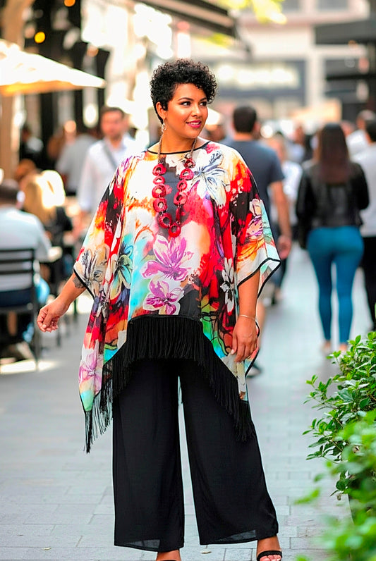 Woman wearing a colorful floral top and black pants in an urban setting