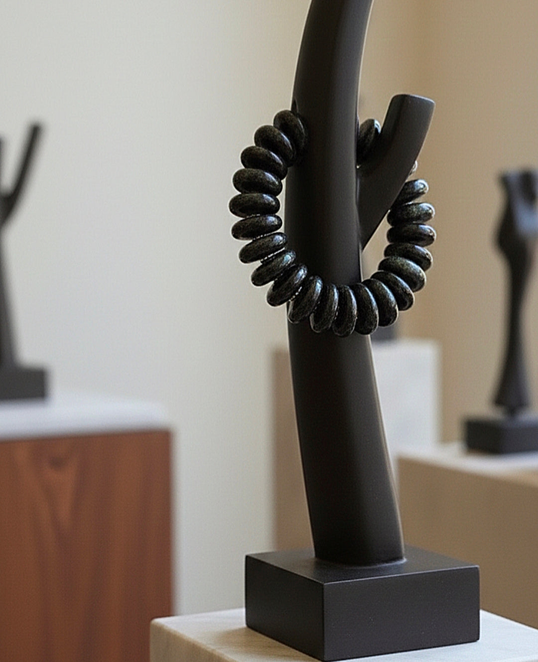 Black abstract sculpture with twisted design on a stand