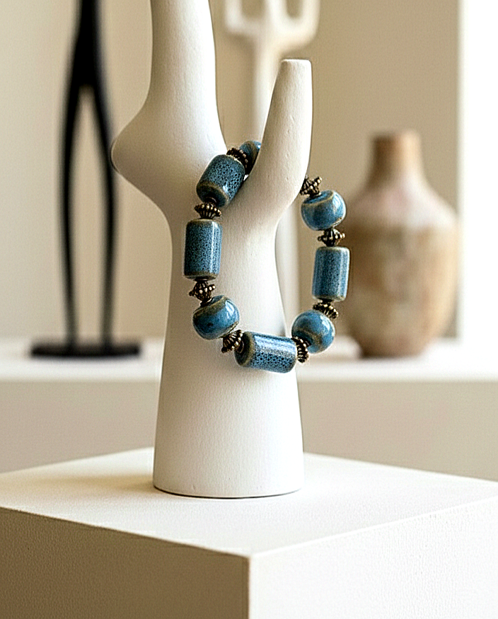Blue beaded necklace on a white mannequin bust with a neutral background