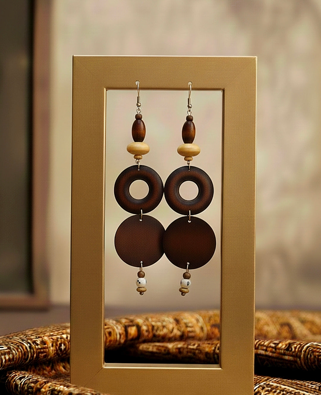Pair of earrings with wooden beads on a reflective surface