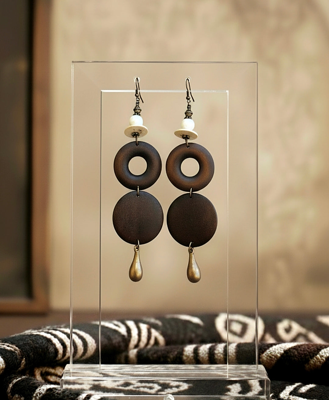 Pair of earrings on a clear stand with a blurred background