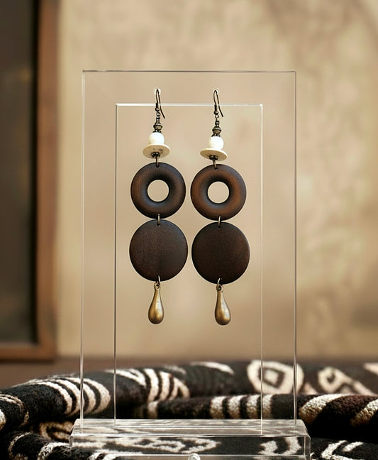 Pair of earrings on a clear stand with a blurred background
