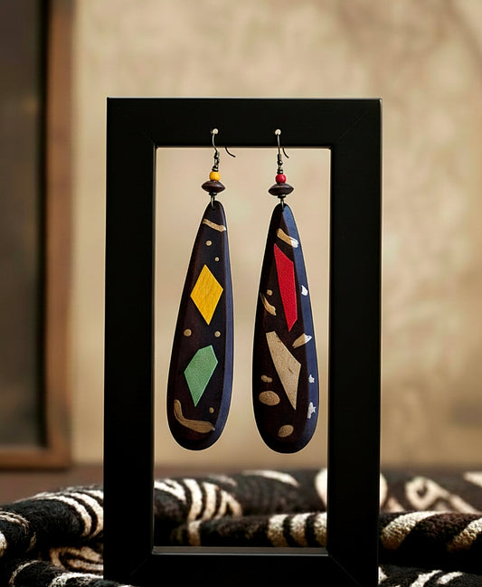 Pair of colorful earrings displayed in a black frame against a neutral background.