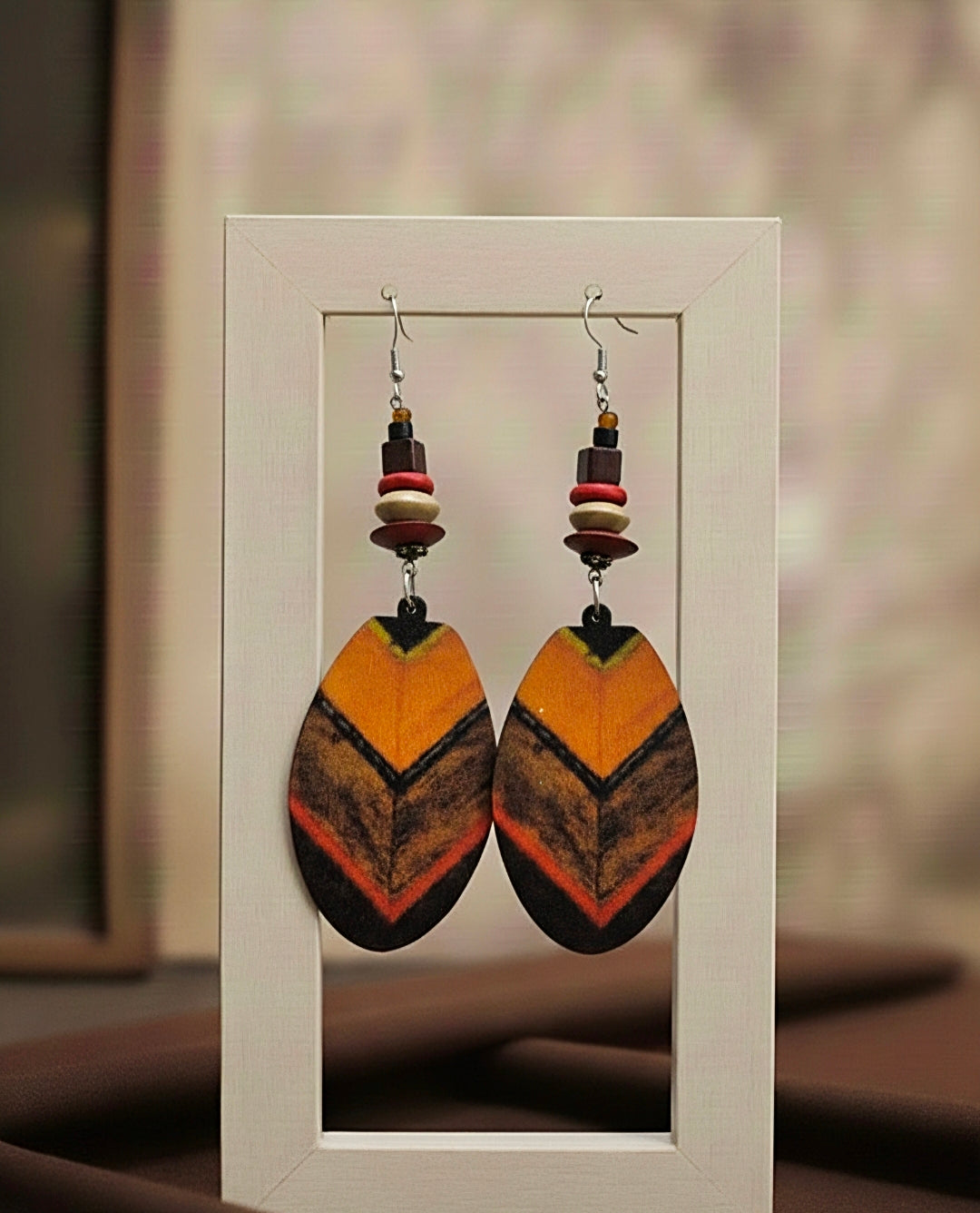 Pair of colorful earrings on a white card with a blurred background