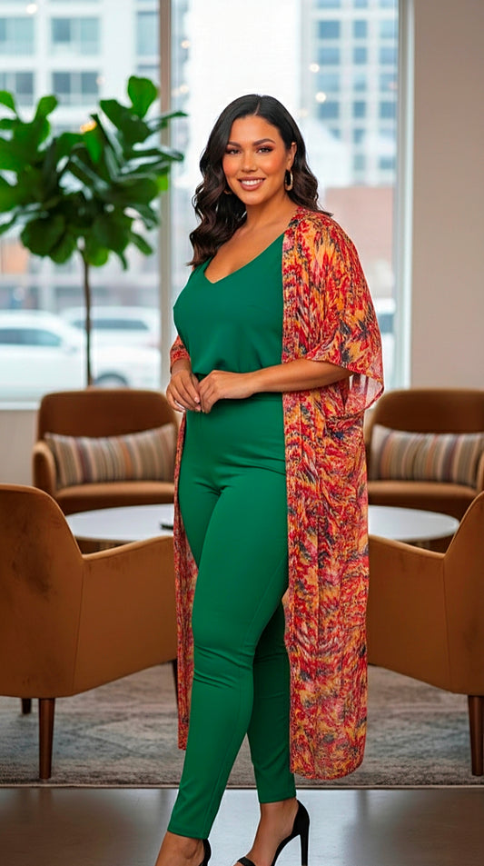Woman in a green outfit with a patterned shawl standing in a modern indoor setting.