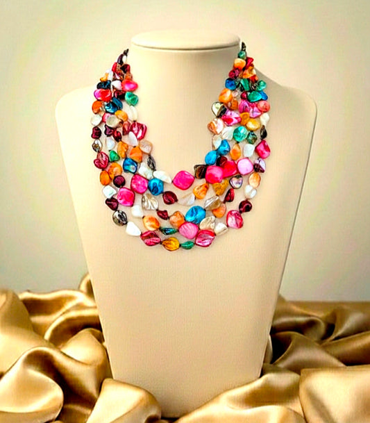 Colorful beaded necklace on a mannequin bust with a gold fabric background