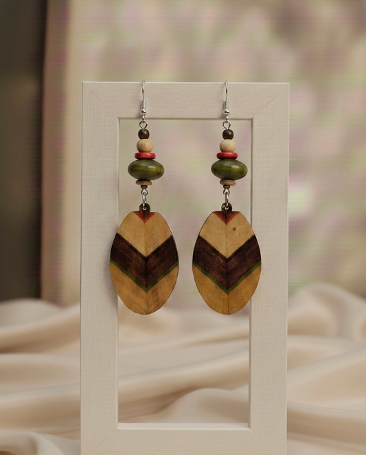 Wooden chevron pattern earrings on a display card with a soft background
