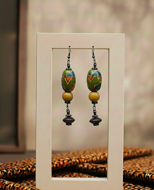 Pair of colorful green beaded earrings displayed in a white frame.