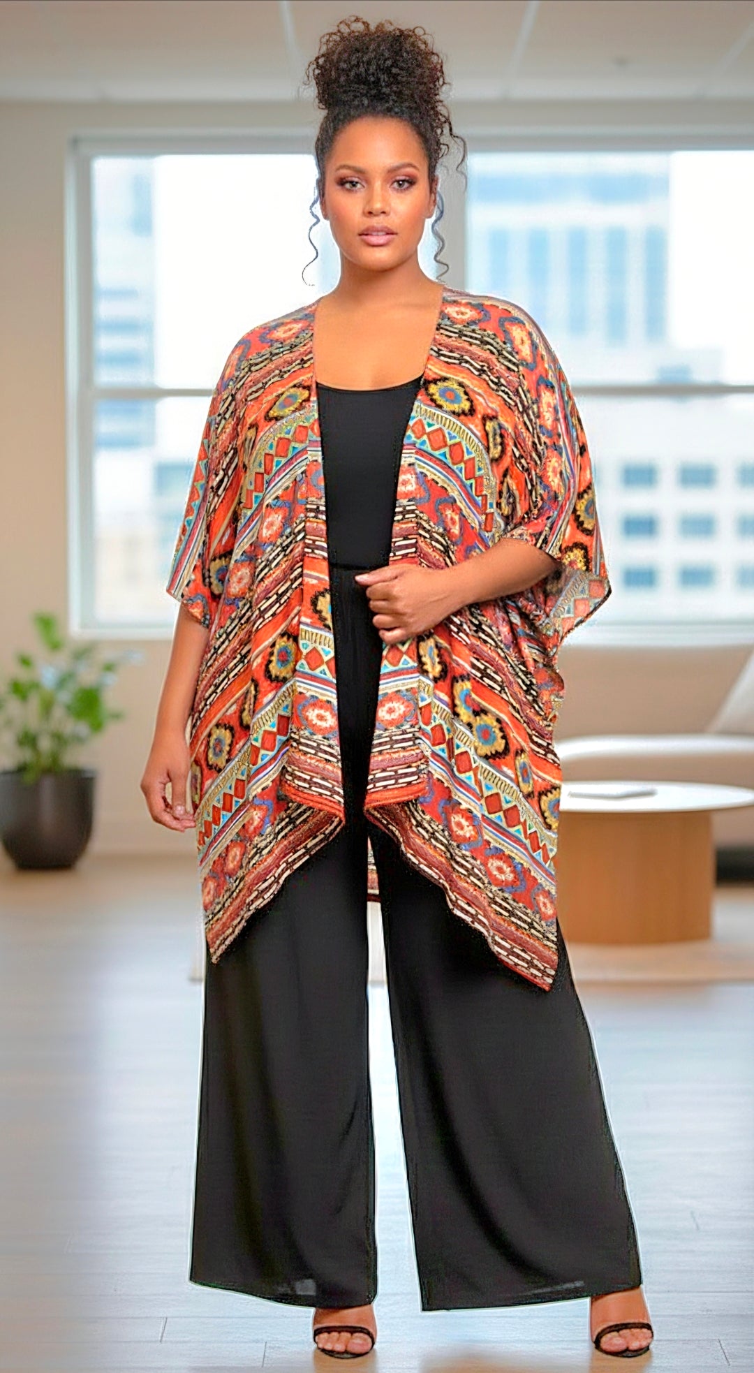 Woman wearing a patterned kimono over a black outfit in an indoor setting.