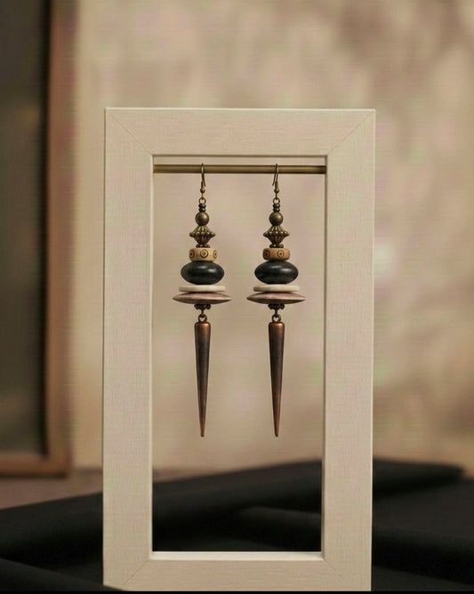 Pair of ornate earrings displayed in a white frame against a neutral background