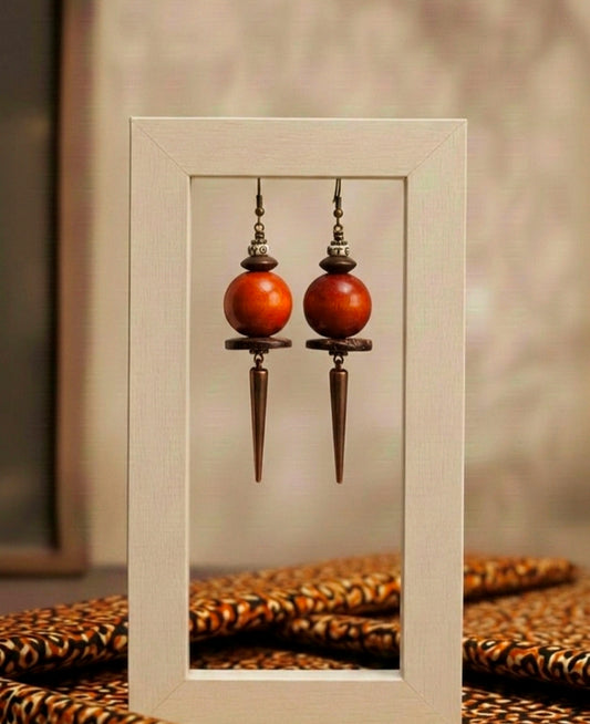 Pair of wooden earrings with long silver hooks displayed in a white frame.