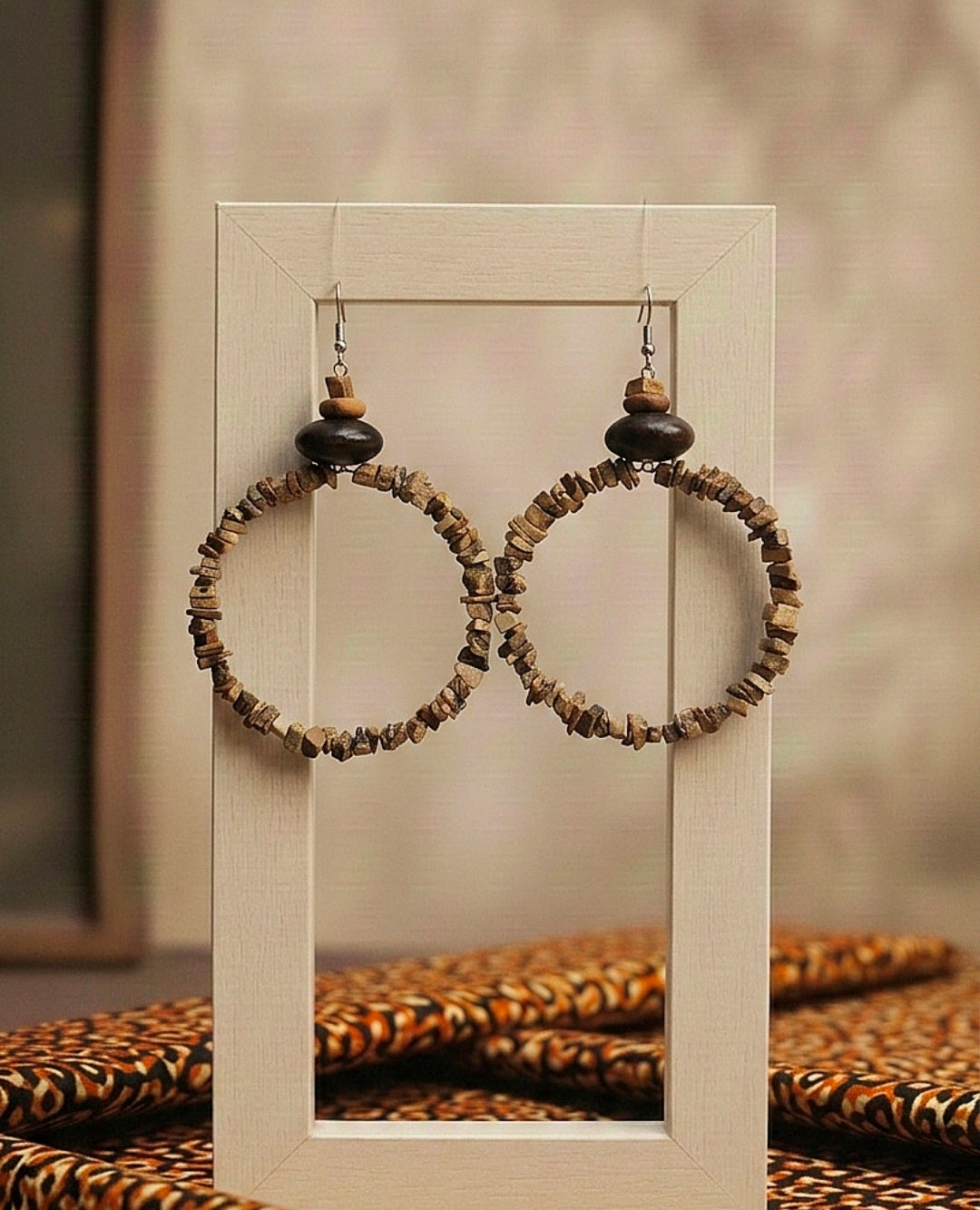 Hoop earrings with wooden beads displayed in a clear box against a neutral background