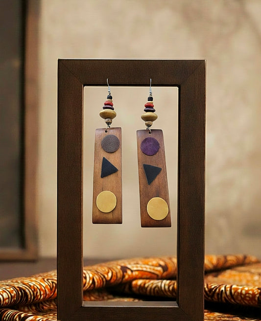 Wooden earrings with colorful geometric shapes displayed in a wooden frame.