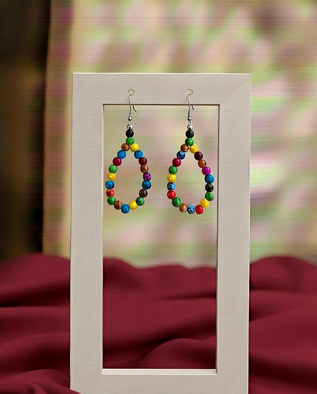 Colorful beaded earrings on a stand with a blurred background