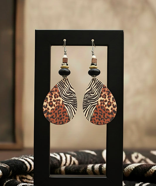 Pair of earrings with leopard and zebra patterned stones on a black stand.