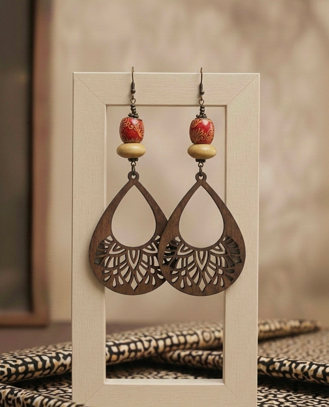 Pair of earrings with intricate designs displayed on a neutral background
