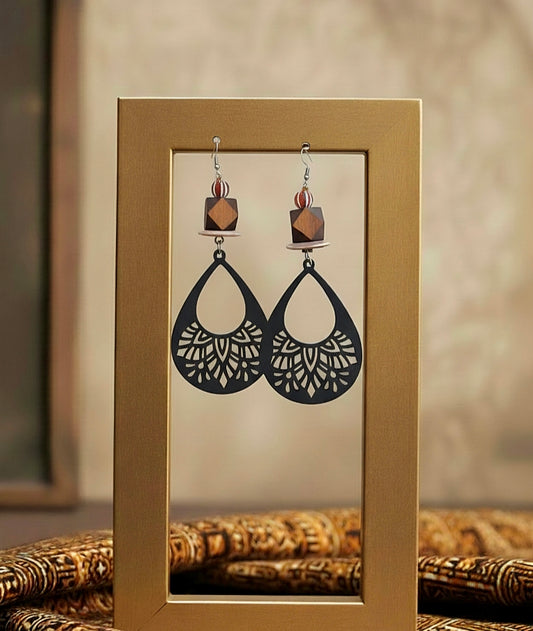 Pair of black earrings with intricate designs displayed in a gold frame.