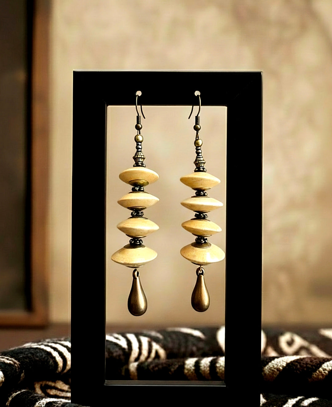 Pair of tan wood earrings with layered design in a mirror frame