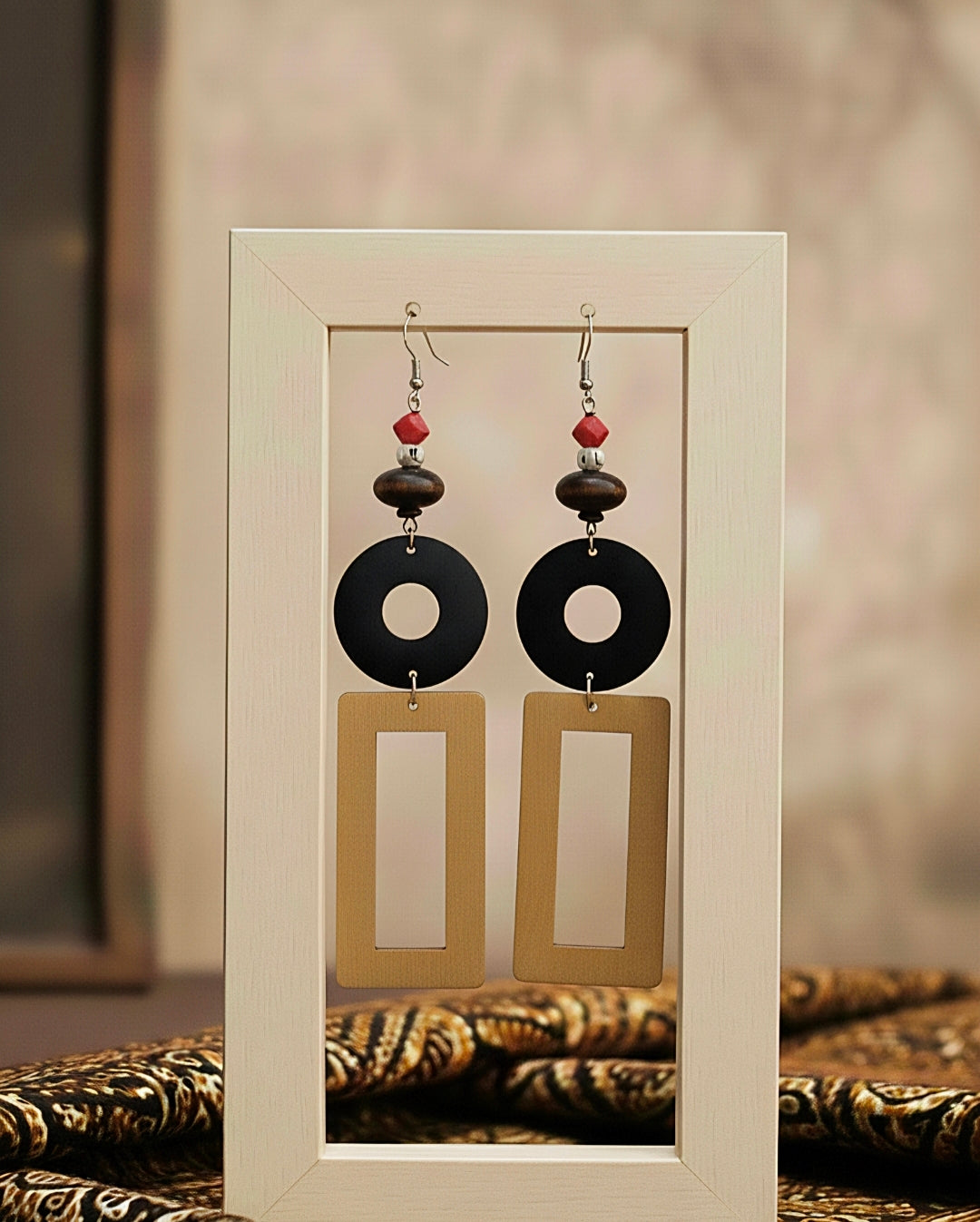 Pair of wood earrings displayed in a clear frame with a neutral background