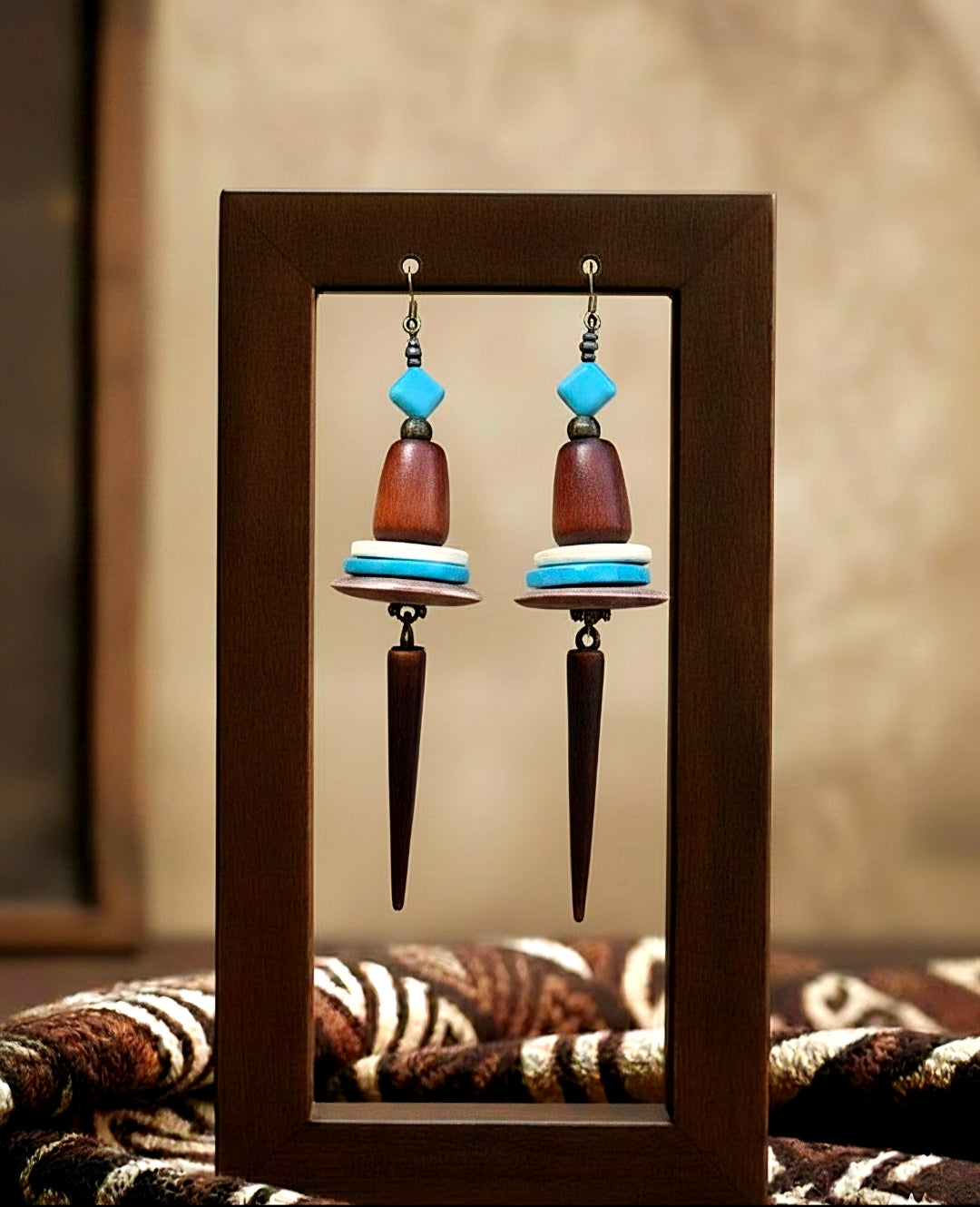Pair of earrings with wooden and blue beads in a wooden frame.