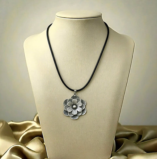 Necklace with a floral pendant on a mannequin bust against a neutral background