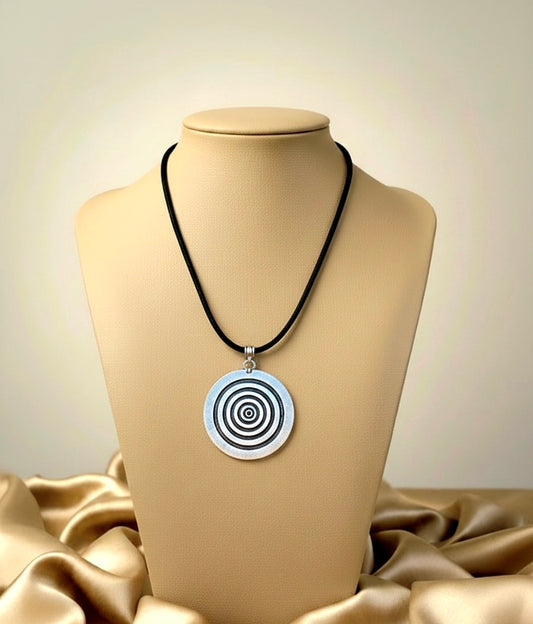 Necklace with a circular pendant on a mannequin bust against a beige background