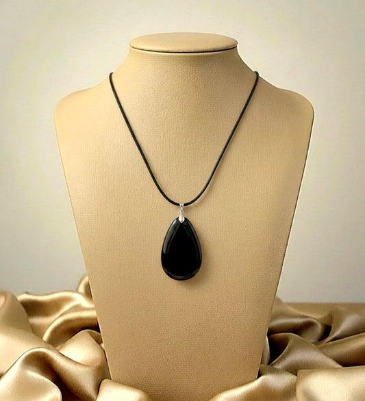 Black teardrop pendant necklace on a mannequin bust with beige fabric background