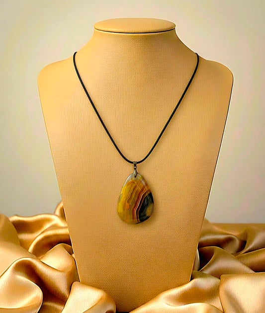 Necklace with a large pendant on a mannequin bust against a beige background